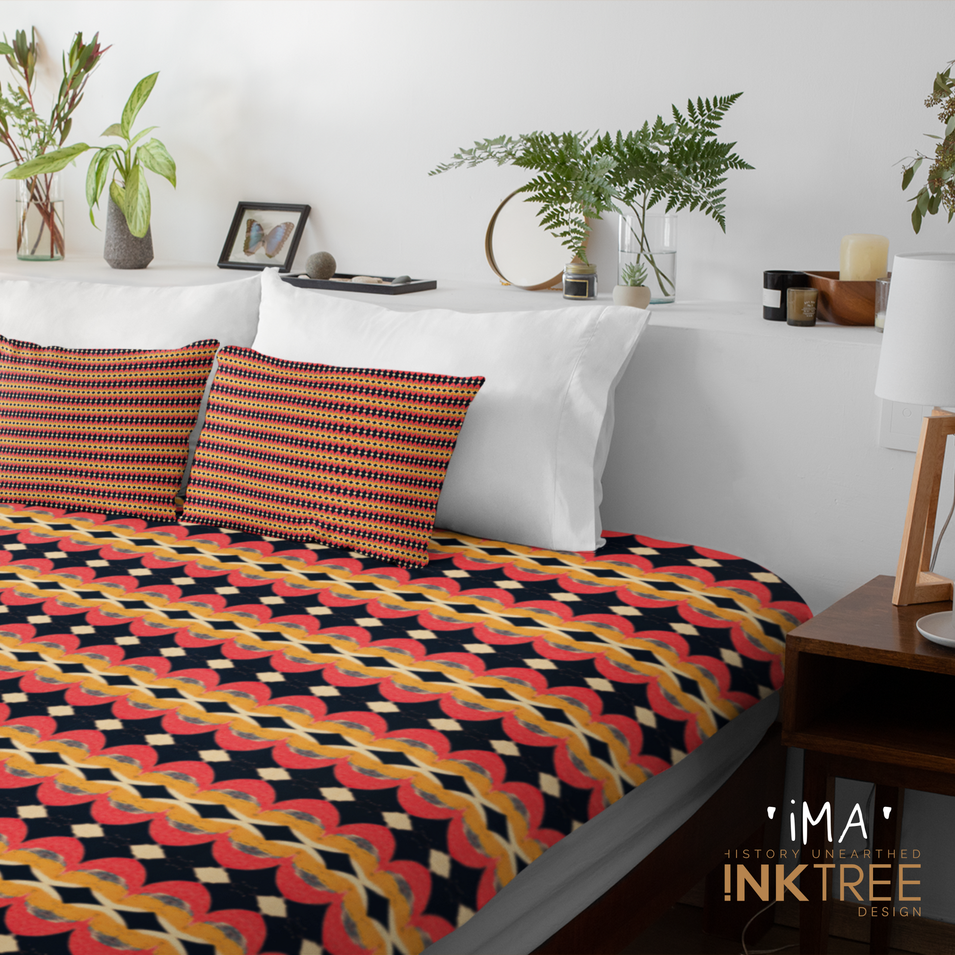A doona cover and front pillows with an orange, black, white and yellow striped horizontal pattern on a bed with a white wall, white pillows and white backboard background. There is a lamp with a white shade and wood base and plants and a small round metal mirror on the back board. There is also a ima, history unearthed ink tree design logo in the bottom right hand corner on it.