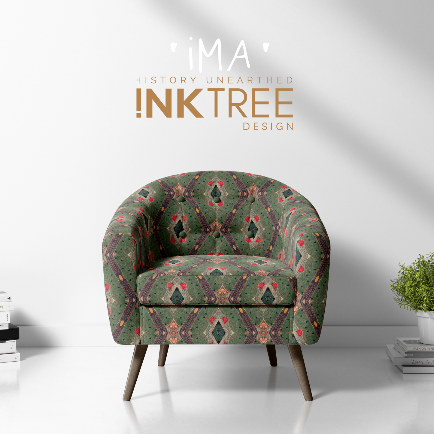 A club chair with a gold, black, red, green and white oriental looking pattern on it with a white wall background and books and pot plant on the floor.  There is a ima history unearthered ink tree design logo on it.