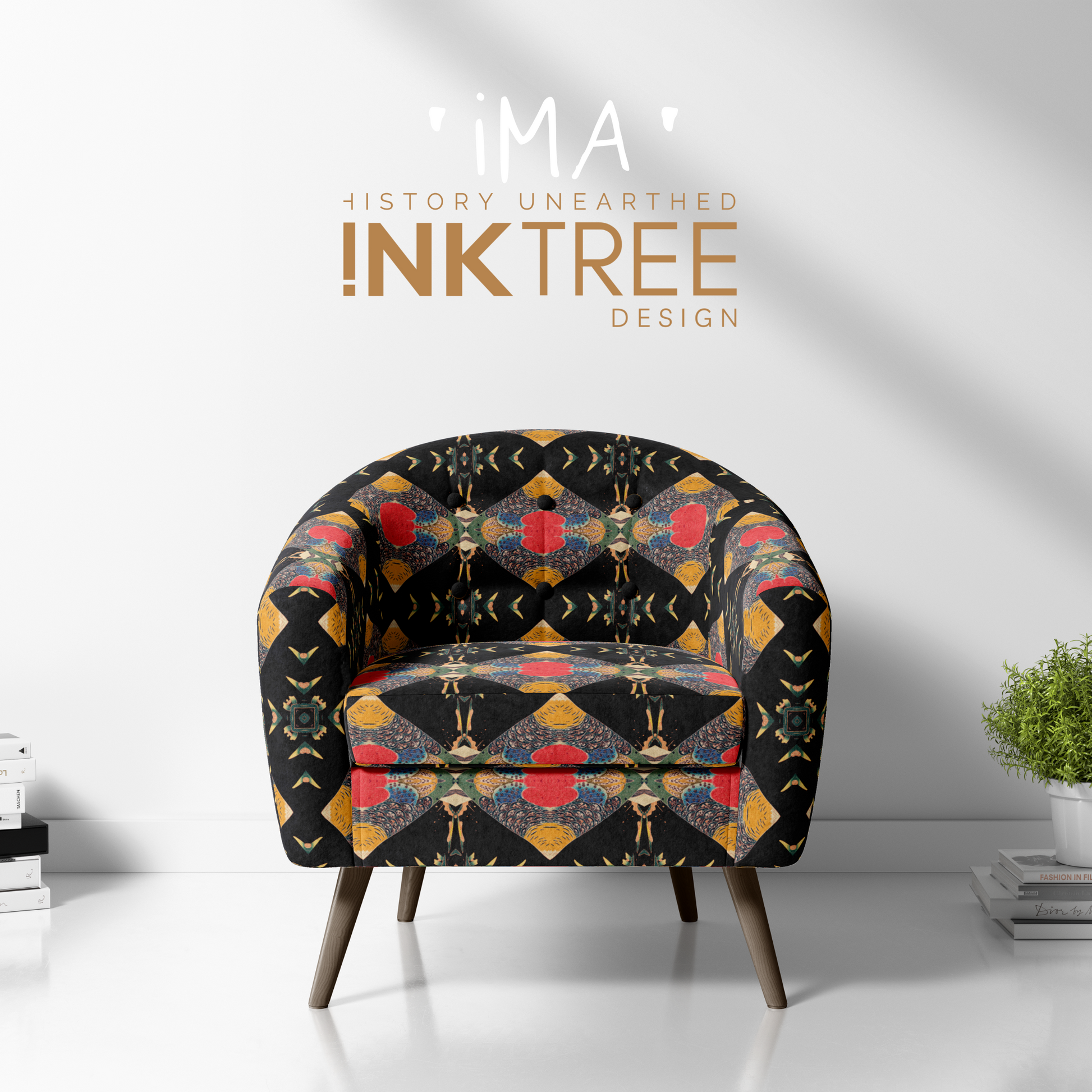 A club chair with a gold, black, blue, red, green and white oriental looking pattern on it with a white wall background and books and pot plant on the floor.  There is a ima history unearthered ink tree design logo on it.
